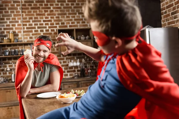 Father and son eating sandwiches — Stock Photo