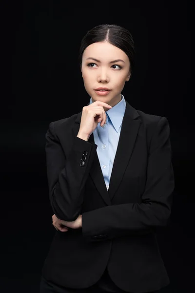 Mujer de negocios pensativa en traje negro - foto de stock