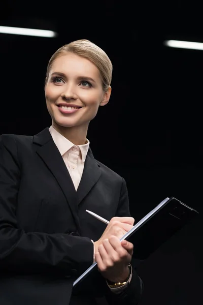 Businesswoman writing in notepad — Stock Photo