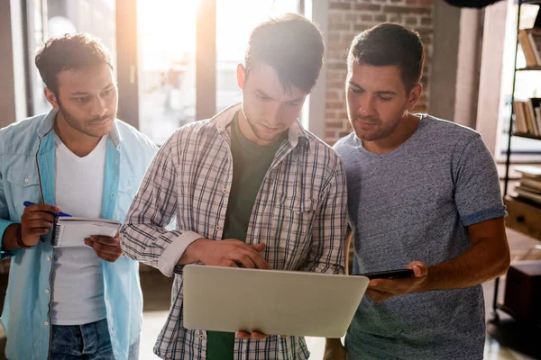 Les hommes travaillant avec un ordinateur portable — Photo de stock