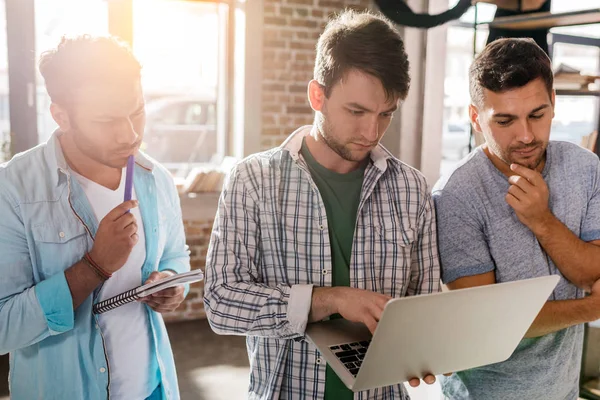 Hombres que trabajan con el ordenador portátil - foto de stock