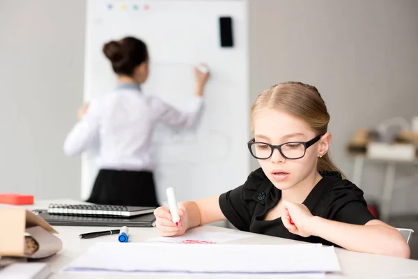 Kleines Mädchen sitzt am Tisch — Stockfoto