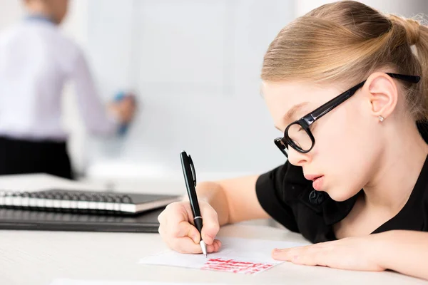 Niña sentada en la mesa - foto de stock