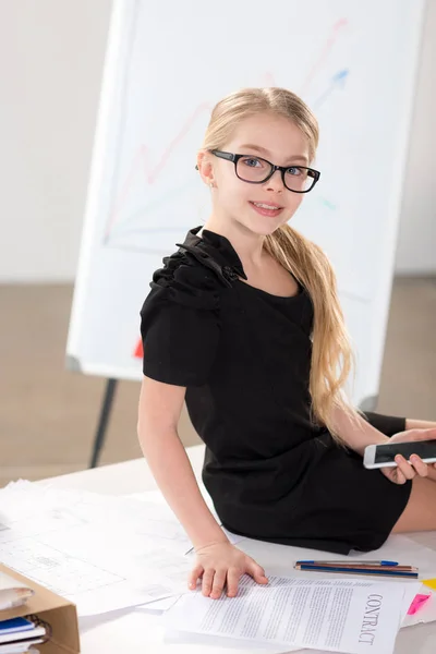 Cute little girl  sitting on table — Stock Photo