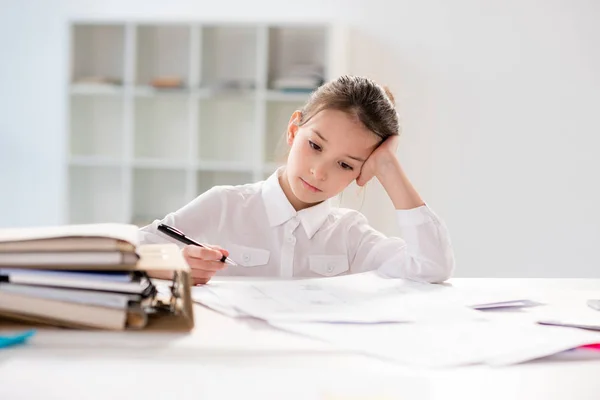 Petite fille assise à table — Photo de stock