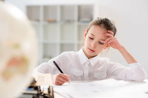 Kleines Mädchen sitzt am Tisch — Stockfoto