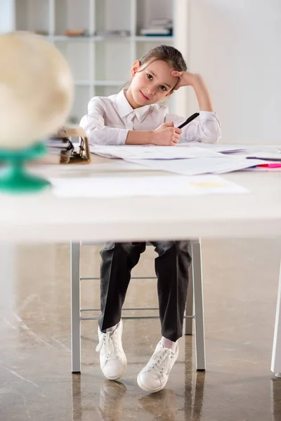 Kleines Mädchen sitzt am Tisch — Stockfoto