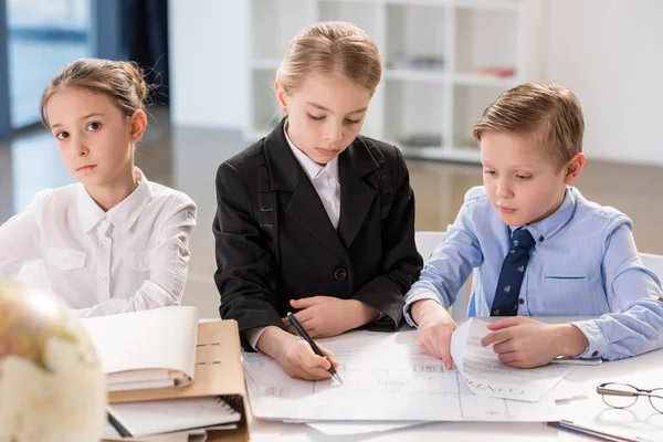 Niedliche Kinder, die mit Papieren arbeiten — Stockfoto
