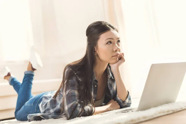 Woman lying on white carpet and daydreaming — Stock Photo