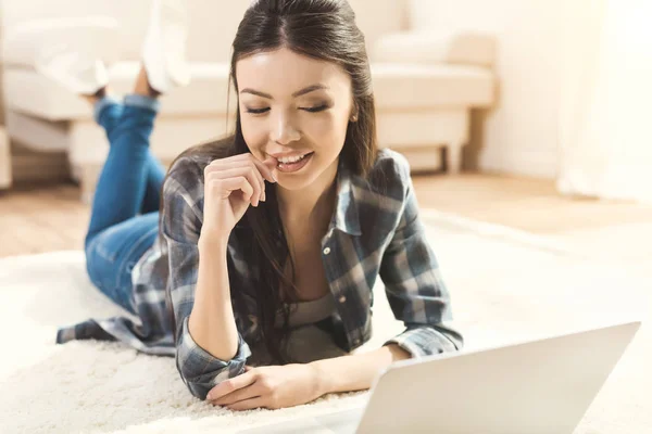 Donna sdraiata sul tappeto e guardando il monitor — Foto stock