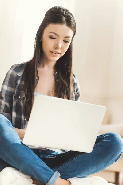Woman sitting on floor and working on laptop — Stock Photo