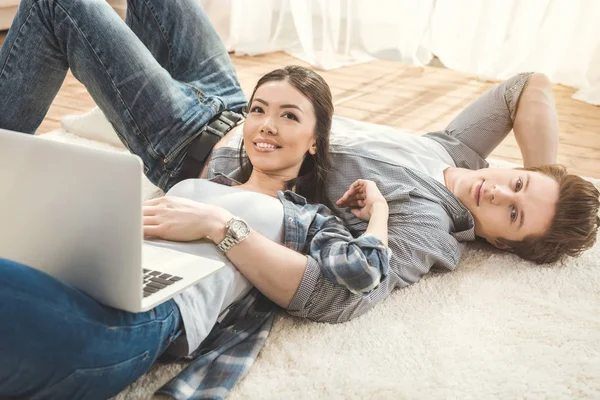 Mujer acostada en el novio y el uso de ordenador portátil - foto de stock