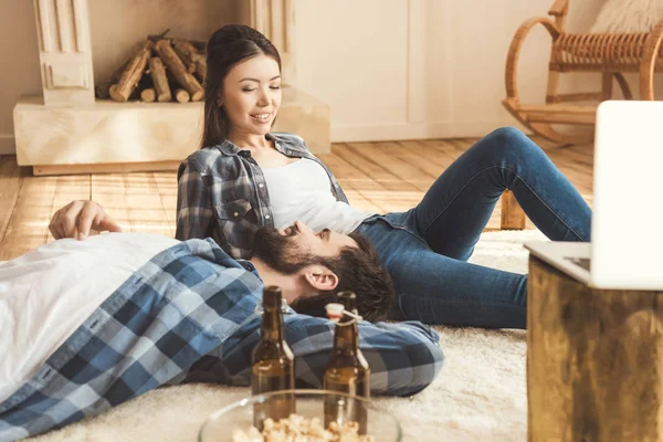 Paar liegt zusammen auf Teppich und redet — Stockfoto