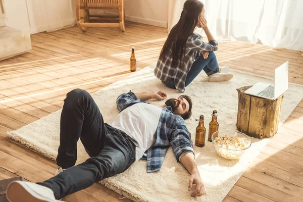 Woman sitting on floor near drunk boyfriend — Stock Photo