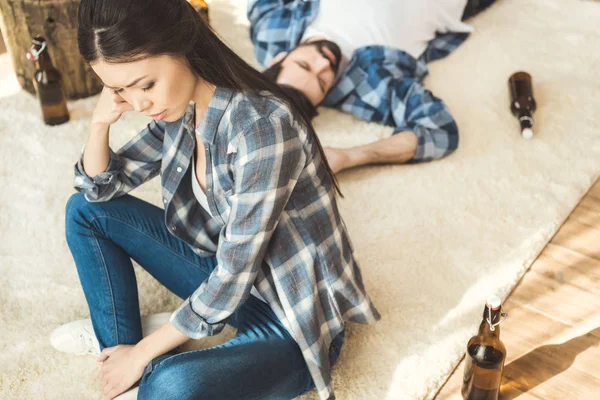 Frau sitzt neben betrunkenem Freund auf dem Boden — Stockfoto