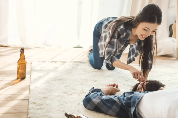 Woman having fun with sleeping boyfriend — Stock Photo