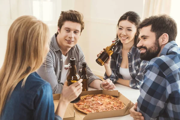 Couples drinking beer and eating pizza — Stock Photo