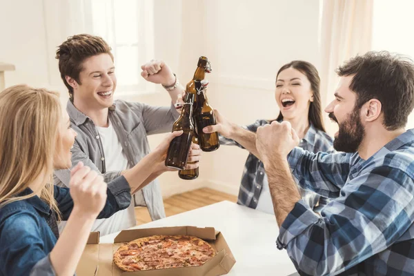 Couples boire de la bière et manger de la pizza — Photo de stock