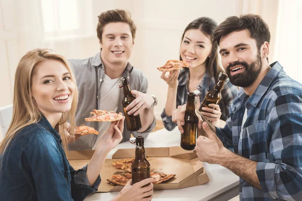 Couples boire de la bière et manger de la pizza — Photo de stock