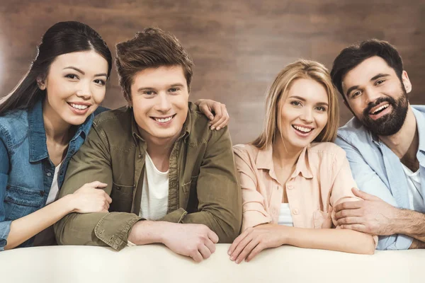 Couples leaning on sofa and looking at camera — Stock Photo