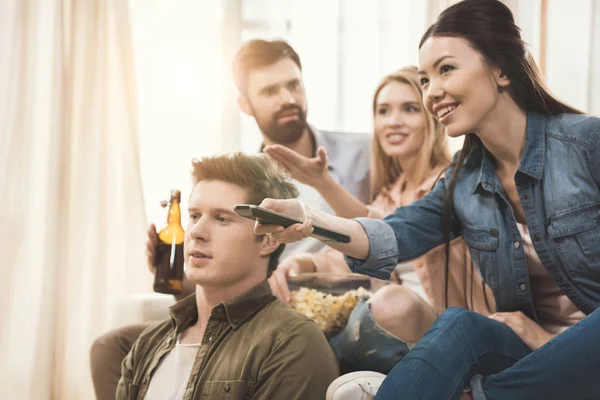 Les gens assis sur le canapé avec du pop-corn et de la bière — Photo de stock