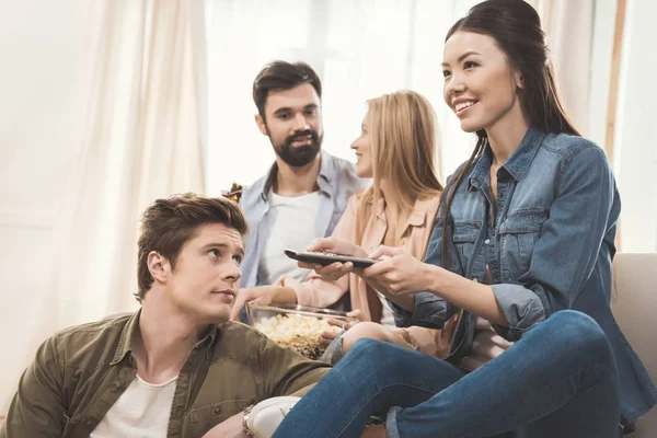 People sitting on couch with popcorn and beer — Stock Photo