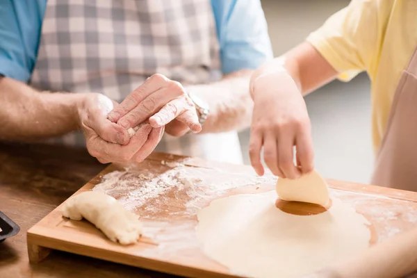 Grandfather and granddaughter making dough — Stock Photo