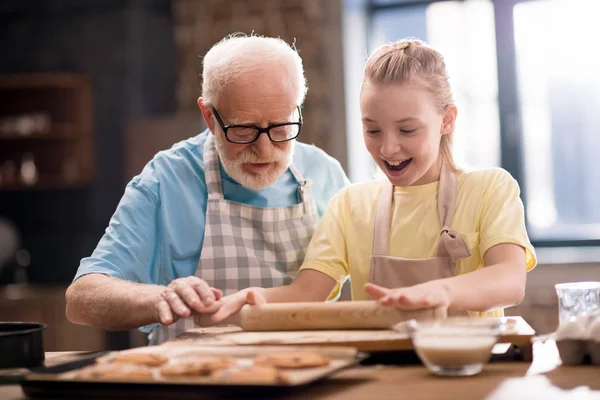 Grandfather and granddaughter making dough — Stock Photo