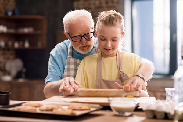 Grand-père et petite-fille faire de la pâte — Photo de stock