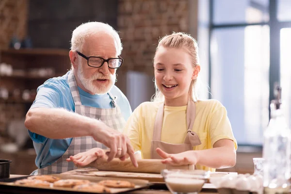Nonno e nipote impastando la pasta — Foto stock