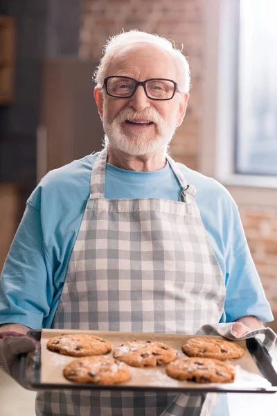 Uomo anziano con biscotti — Foto stock