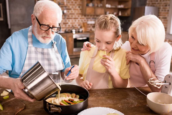 Abuelos y niña cocinar juntos - foto de stock