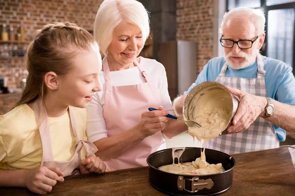Abuelos y niña cocinar juntos - foto de stock