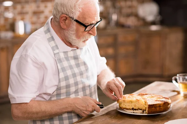 Человек режет домашний пирог — стоковое фото