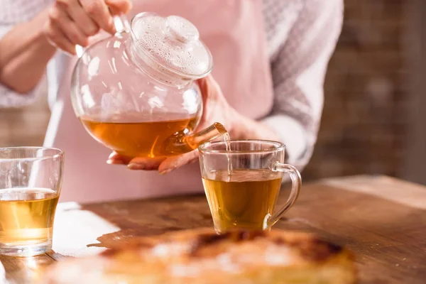 Woman pouring hot tea — Stock Photo