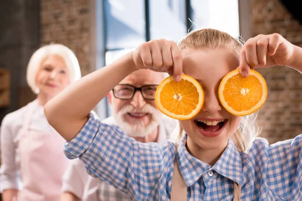 Menina segurando fatias de laranja — Fotografia de Stock