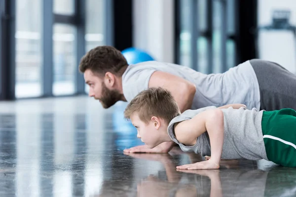 Hombre y niño haciendo flexiones - foto de stock