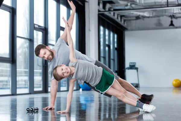 Hombre y niño haciendo ejercicio de tablón - foto de stock