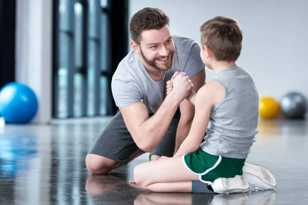 Niño con el hombre joven en el gimnasio - foto de stock