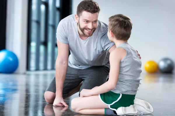 Niño con el hombre joven en el gimnasio - foto de stock