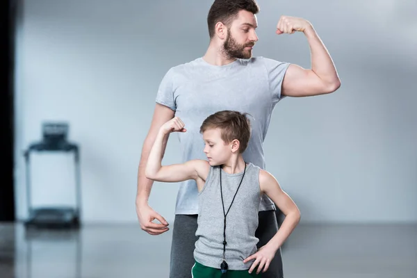 Garçon avec jeune homme montrant des muscles — Photo de stock