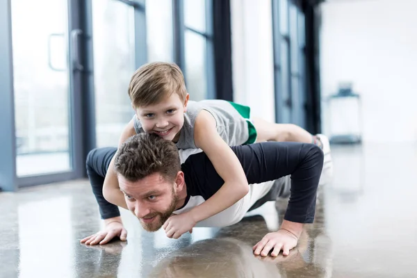 Hombre haciendo flexiones con chico - foto de stock