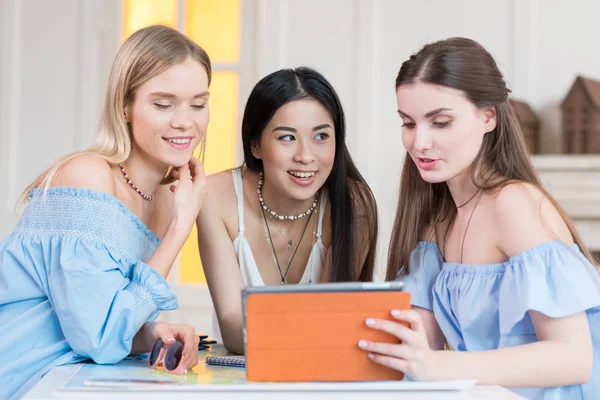 Frauen halten im Sitzen digitales Tablet in der Hand — Stockfoto