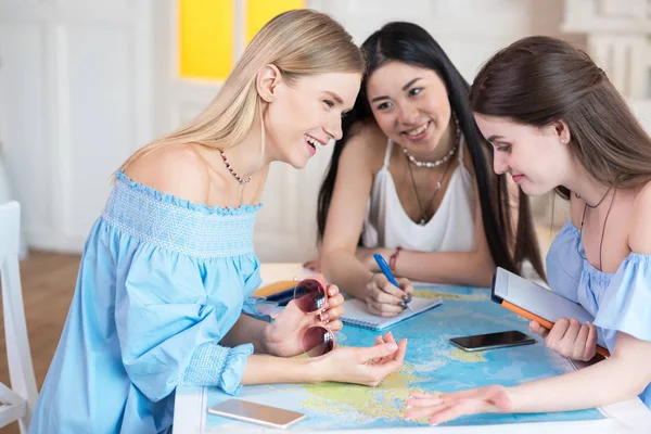 Mujeres viajeros mirando el mapa del mundo - foto de stock