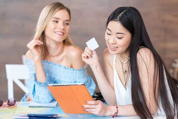 Frauen halten im Sitzen digitales Tablet in der Hand — Stockfoto