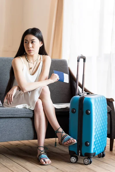 Asian woman traveler sitting with suitcase — Stock Photo