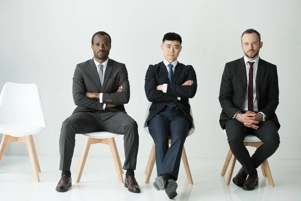 Empresarios multiculturales sentados - foto de stock