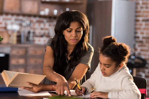 Mother with daughter doing homework — Stock Photo