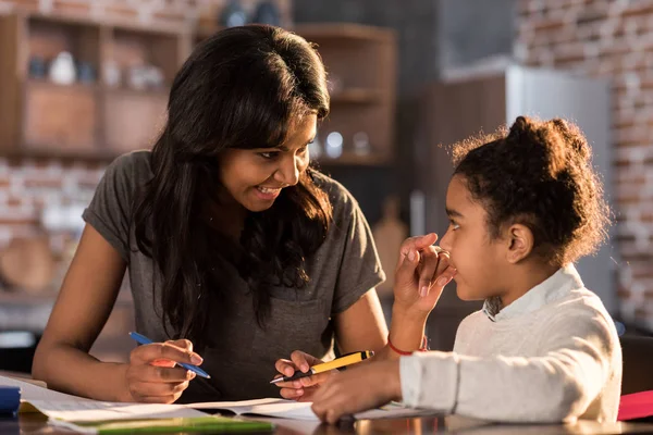 Mère avec sa fille faisant ses devoirs — Photo de stock