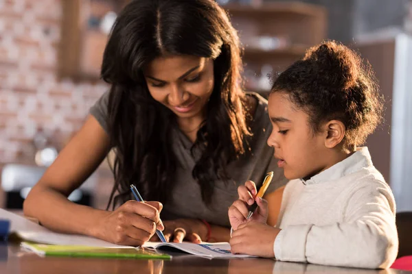 Mère avec sa fille faisant ses devoirs — Photo de stock